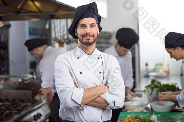 年轻厨师站在餐厅商业厨房的肖像