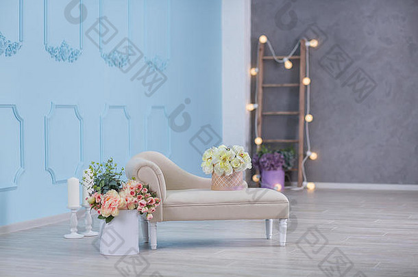 工作室室内装饰，带有浅色暖色花朵和休闲复古家具。