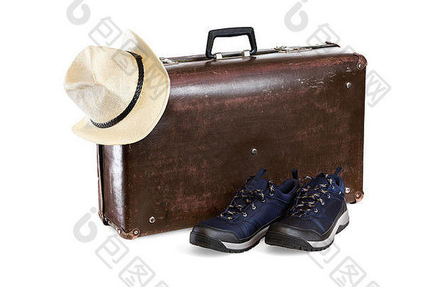 旧棕色纤维手提箱，白色背景上有帽子和运动鞋