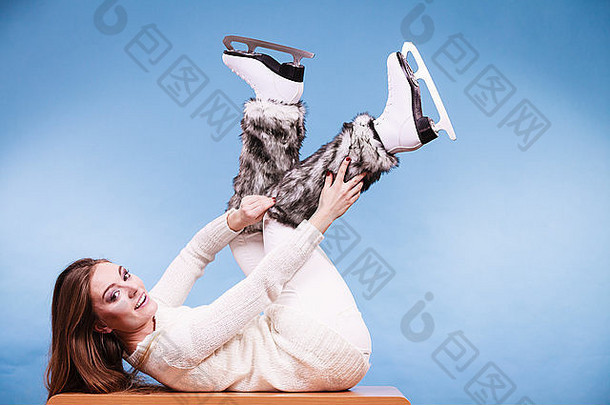 穿着溜冰鞋和皮草<strong>保暖</strong>袜子的女人。准备滑冰的女孩。<strong>冬季</strong>体育活动。蓝色摄影棚拍摄