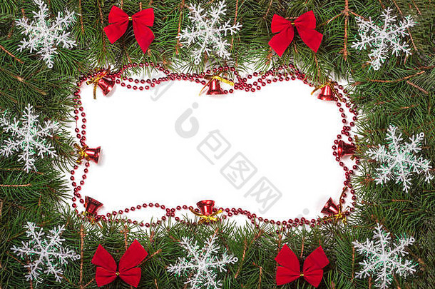 圣诞框架由冷杉树枝制成，装饰有蝴蝶结、铃铛和雪花，并在白色背景上隔离开来