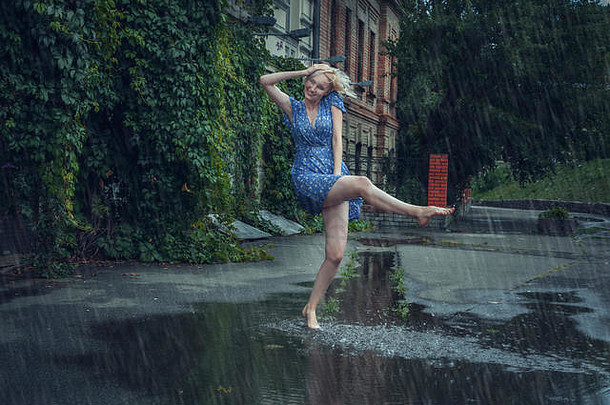 年轻的女人嬉戏光着脚水坑夏天雨