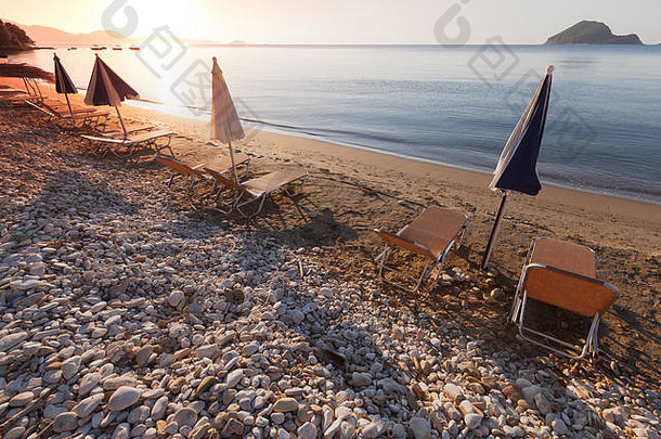 希腊Zakynthos岛海滩上带着雨伞和躺椅的早晨海洋景观。暑期热门旅游目的地