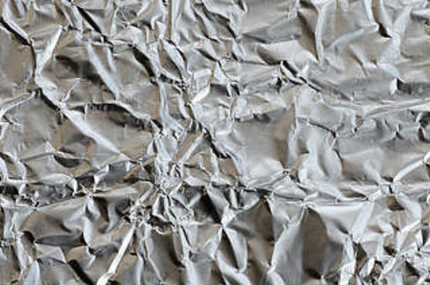 压碎的锡、铝、银箔背景的起皱薄片，表面有光泽、皱折，形成纹理。