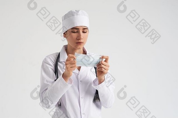 在白色背景上，年轻女医生戴上医用防护面罩的肖像，复印空间