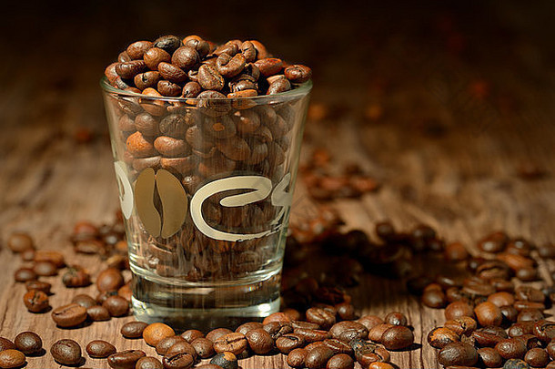 一杯木制背景的咖啡，里面装满了咖啡豆