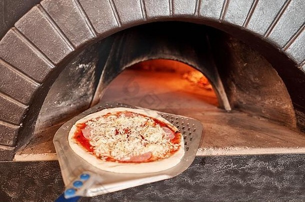 意大利那不勒斯餐厅，在传统木烤箱中烘烤美味的玛格丽塔比萨饼的生坯。原汁原味的那不勒斯披萨。炽热的煤。