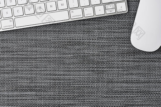 在灰色背景上使用白色计算机键盘和鼠标的业务组合。具有文本空间的俯视图。