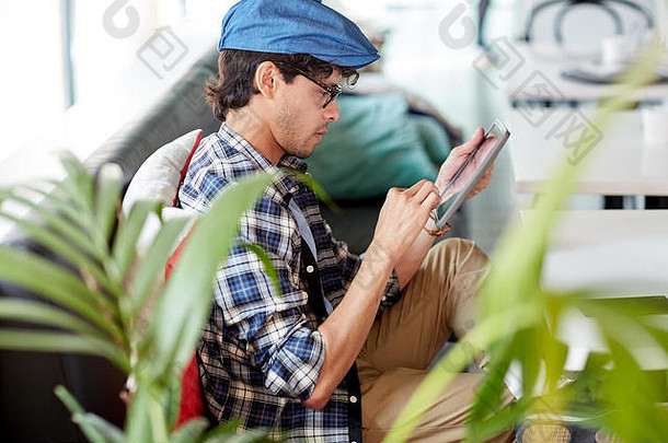 坐在咖啡桌旁的男子手持平板电脑