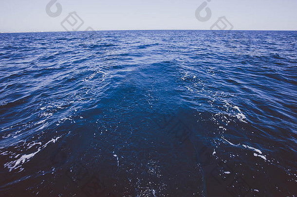 海上地平线上有一艘<strong>帆船</strong>的场景，深蓝色的法国地中海。