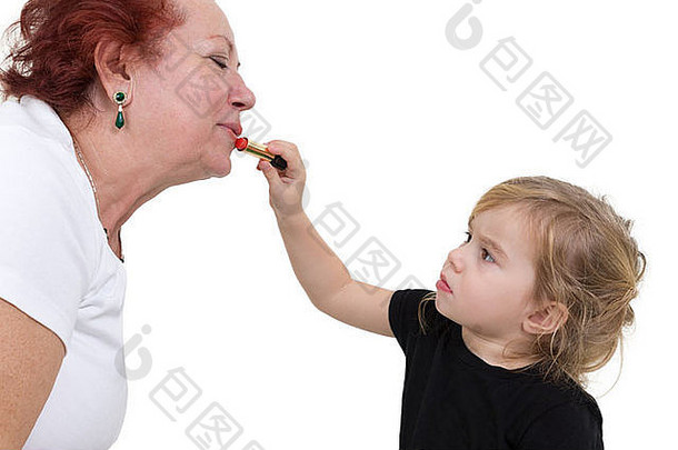 年轻的女孩集中应用口红祖母的嘴唇工作室肖像白色