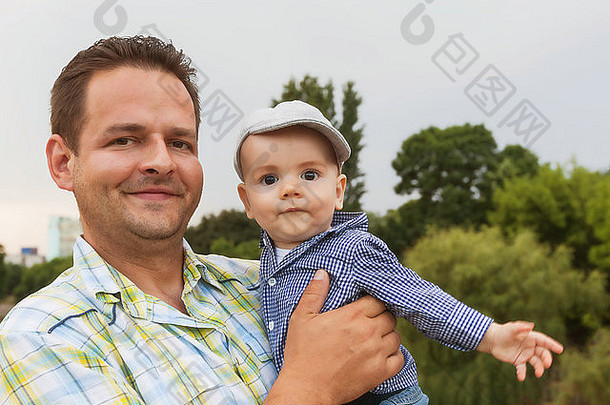 一位快乐的父亲紧抱着他八个月大的婴儿的画像
