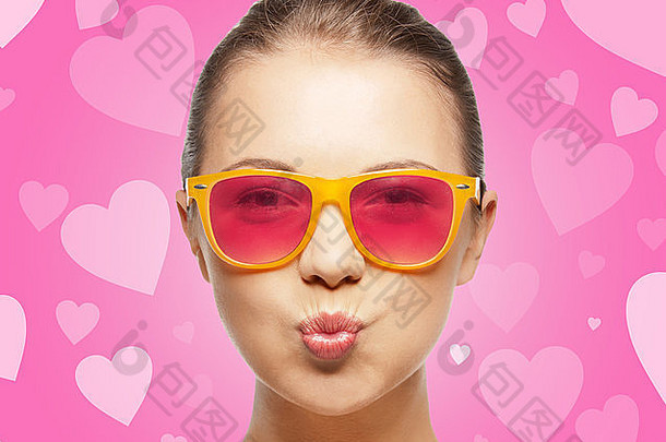 戴粉红色太阳镜的女孩吹吻