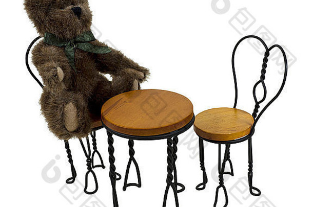 泰迪熊坐在一个小酒馆里，里面有一张桌子和一套方便用餐的椅子——包括小径