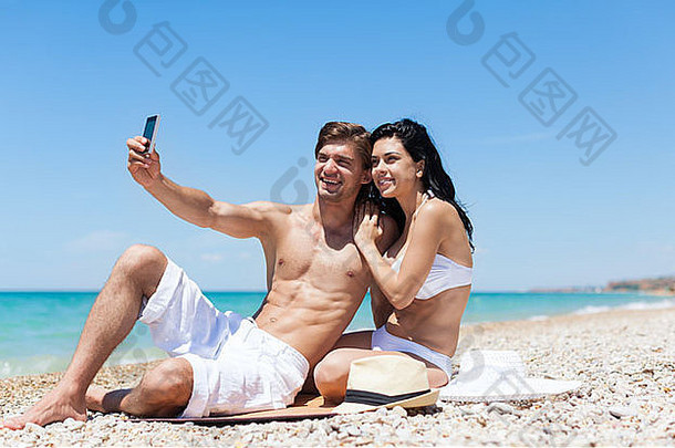 海滩上的情侣用手机自拍