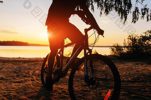 日落时骑自行车的男孩