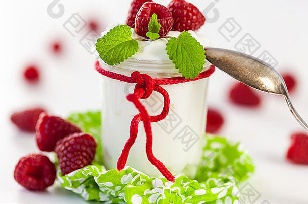 新鲜成熟的覆盆子配上一瓶健康酸奶或凝块奶油，作为美味的甜点或早餐，并留有空间