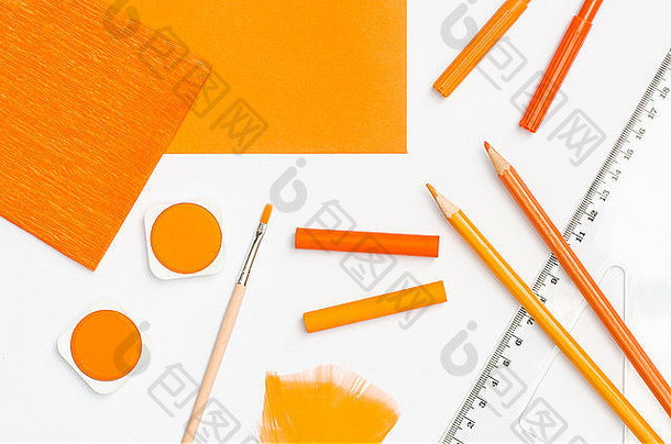 白色纸张背景上的橙色学校用品