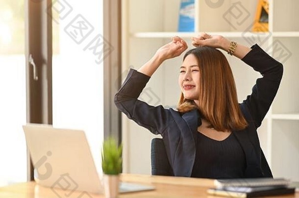 亚洲女商人在<strong>办公</strong>桌旁用笔记本电脑<strong>工作</strong>时伸展身体放松<strong>的</strong>照片。<strong>在家工作的</strong>概念。远程<strong>工作</strong>