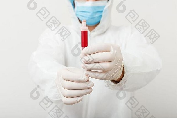 冠状病毒2019冠状病毒疾病的检测。医生穿着防护医疗服、生物危害、医用口罩、白色防护手套