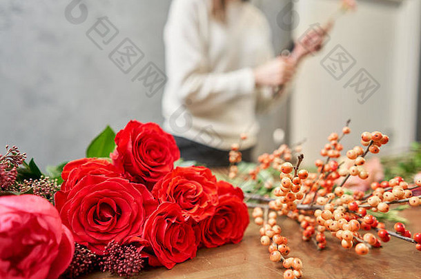 一步一步地，花商女人创造了一束美丽的红色混合花。漂亮的新鲜的一束。教育、硕士班和花卉学课程