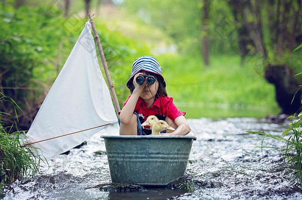 可爱的孩子男孩玩船鸭子河航行boathing孩子有趣的童年幸福概念