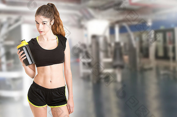 女人喝蛋白质摇锻炼健身房
