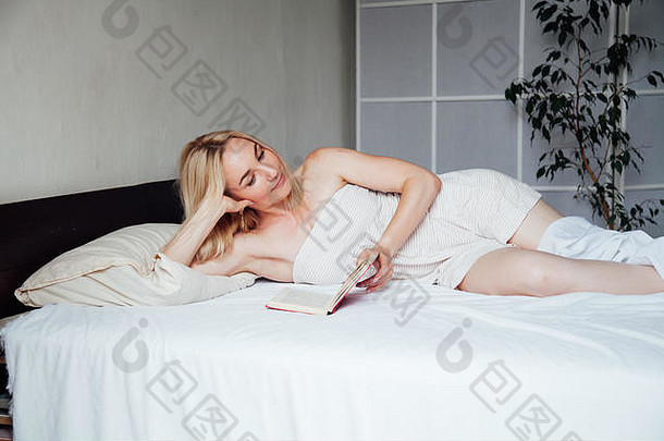 金发女郎早上躺在床上看书