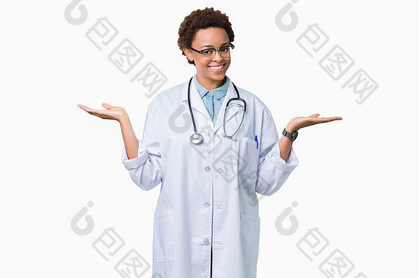 年轻的非裔美国女医生，穿着医用外套，在孤立的背景下微笑着，双手张开手掌，展示和<strong>广告公司</strong>