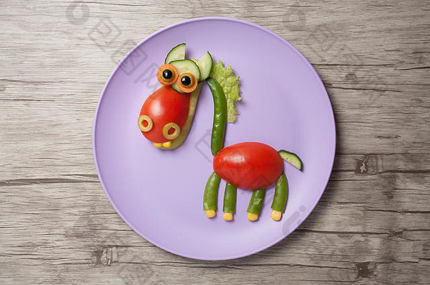 在盘子和桌子上做的有趣的蔬菜马