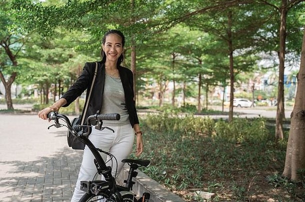 女人亚洲年轻的工人站折叠自行车