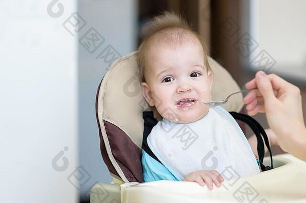 婴儿用勺子吃牛奶粥