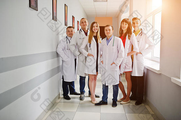 一群穿着白大褂的年轻医生在医院里摆姿势。