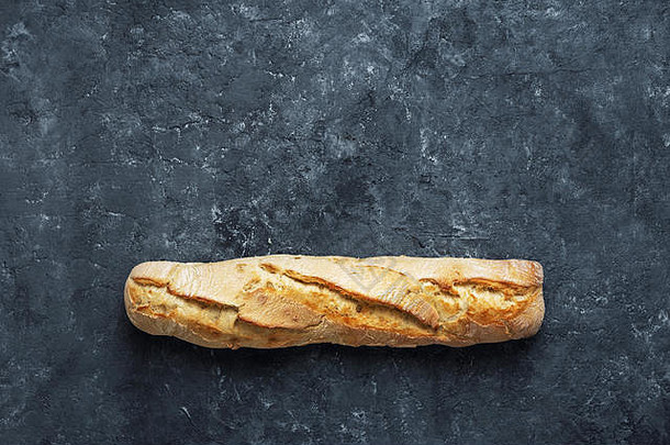 深色石头背景上的新鲜法式面包，带有空间俯视图