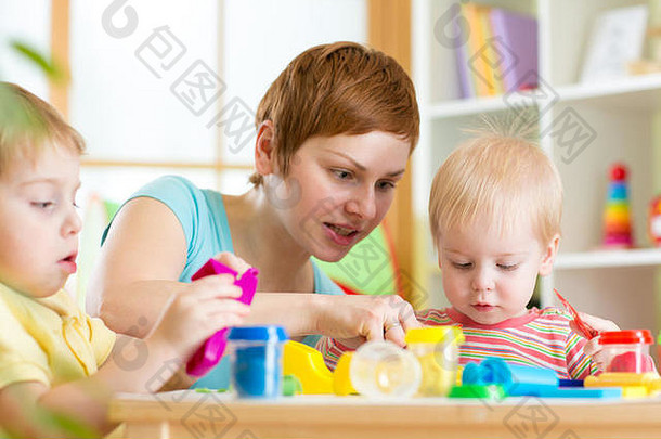 母亲教她的孩子们用五颜六色的玩具面团工作