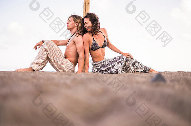 美丽的年轻的千禧一代夫妇坐在沙滩上-暑假旅游概念与男女关系-不同的si