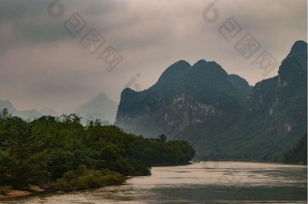 桂林中国河景观黑暗绿色覆盖岩溶山灰色的Cloudscape小船地平线银