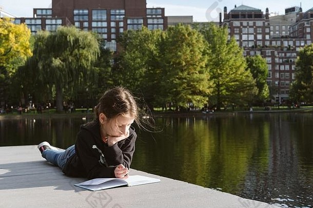女孩专业阅读池塘放松教育概念