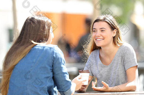 阳光明媚的一天，两个快乐的女人坐在公园里聊天