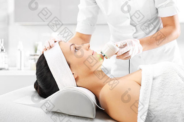 这名妇女在美容院做面部美容时用超声波红外线对脸部进行美容治疗