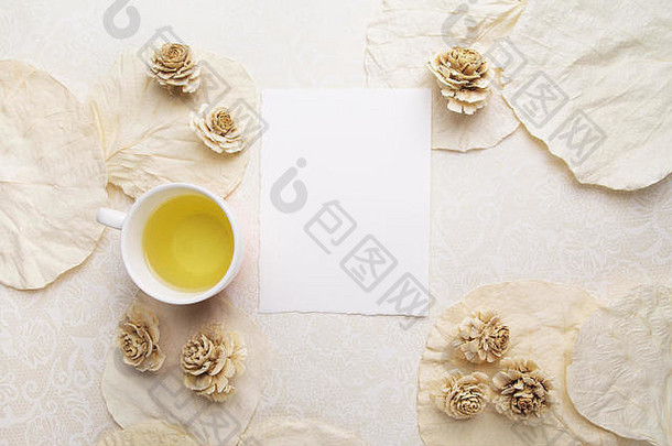一杯茶，干花和白色背景上的空白卡片。文本的可用空间。俯视图
