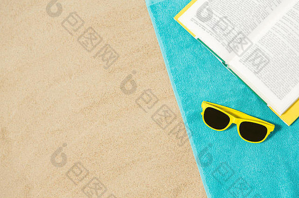 太阳眼镜和沙滩上的书沙滩上的毛巾