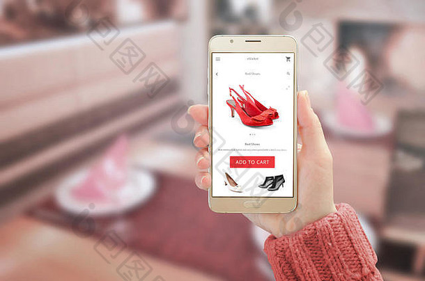 女士在设备显示屏上展示带有在线购物应用程序的现代金色智能手机。女士穿红色鞋子并添加到购物车按钮。