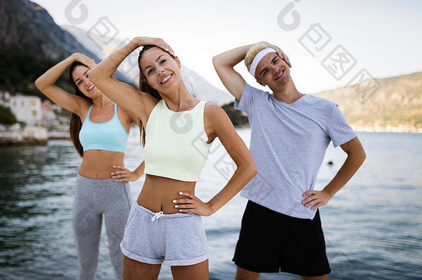 一群快乐的朋友或运动员在户外锻炼和伸展