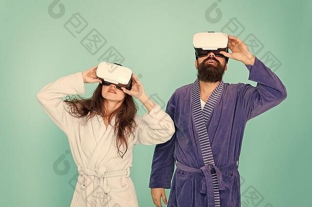 从未来科技开始。数码夫妻。家庭关系的创新。创造你的现实。虚拟现实的新世界。一对夫妇戴着虚拟现实耳机。女孩和男人穿着浴衣放松。