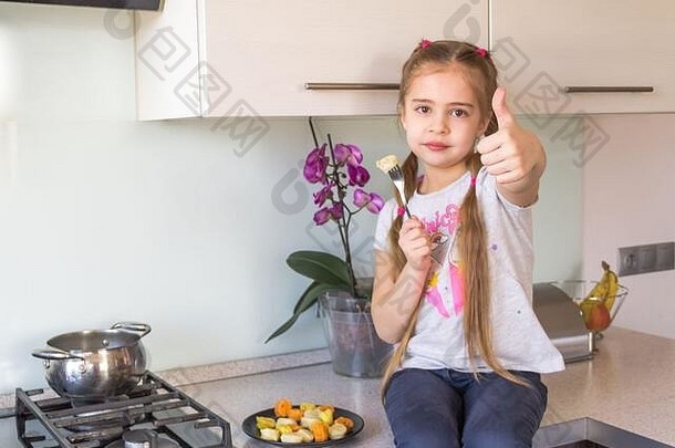 小女孩正在吃五颜六色的饺子。冠状病毒检疫概念。呆在家里。