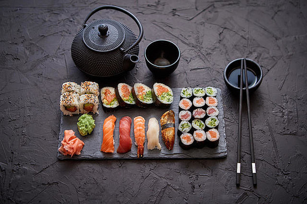 各种各样的寿司卷放在黑石板上