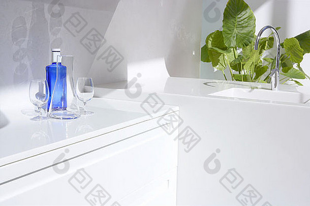 白色现代厨房细节、蓝色水瓶和绿色植物