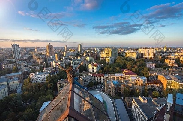乌克兰基辅，坐在现代化建筑屋顶上的女人。在基辅市的屋顶上攀爬的极限<strong>女孩</strong>。Kie屋顶上的日落时间