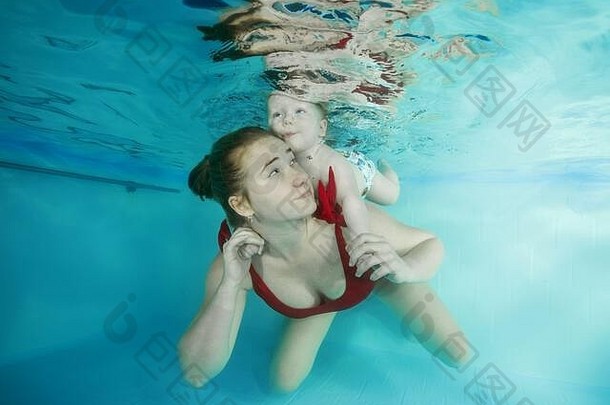 妈妈和一个小儿子在游泳池里潜水
